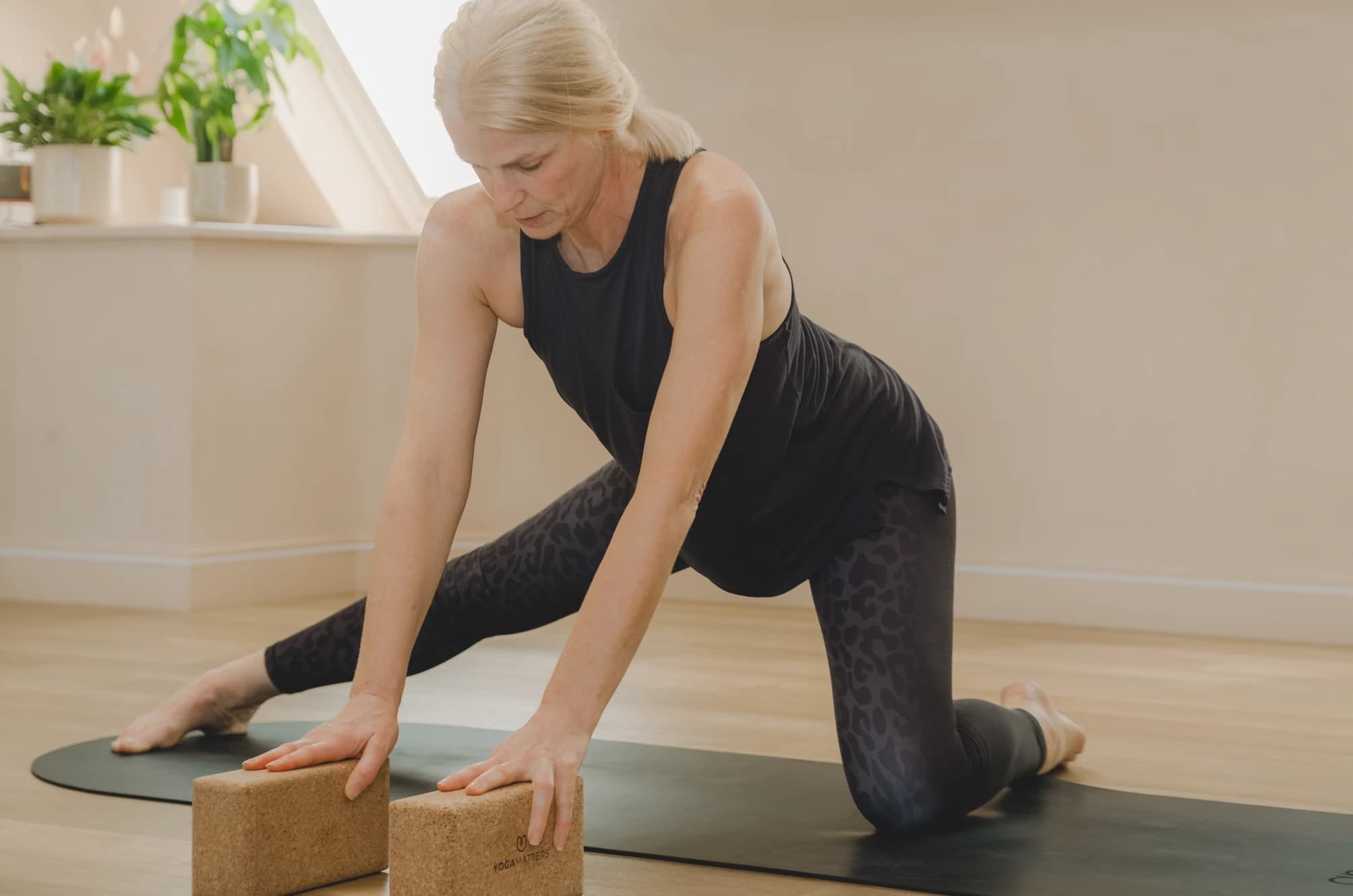Woman stretching with yoga blocks during a Pilates mat class at Body Works West