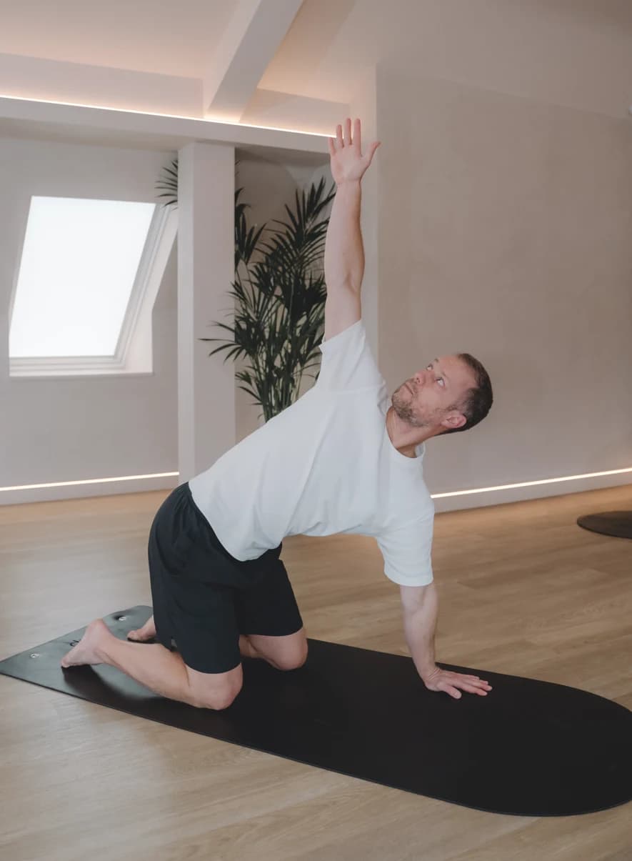 Man in a kneeling yoga stretch during a class at Body Works West