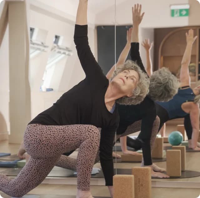Member stretching during a Reformer Pilates class at Body Works West