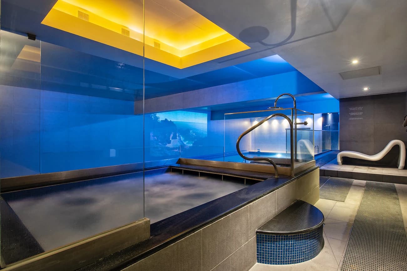 Indoor spa pool and jacuzzi with ambient blue lighting at Body Works West